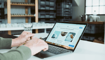 Person arbeitet am Laptop an einer Jimdo-Website im Büro – Website erstellen leicht gemacht für Selbstständige