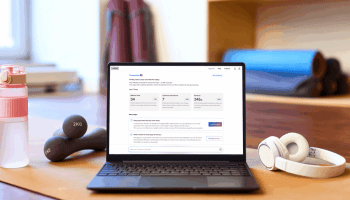 A laptop showing the Jimdo Companion dashboard with website analytics and AI business recommendations.
